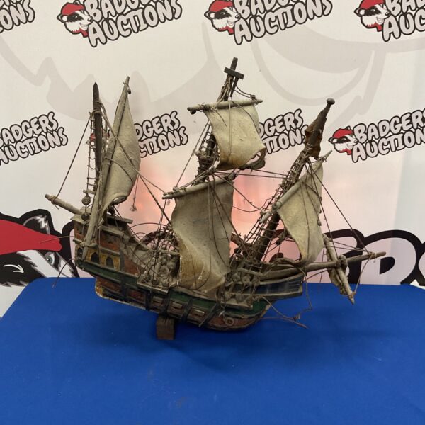 Detailed antique ship model with weathered sails and rigging.