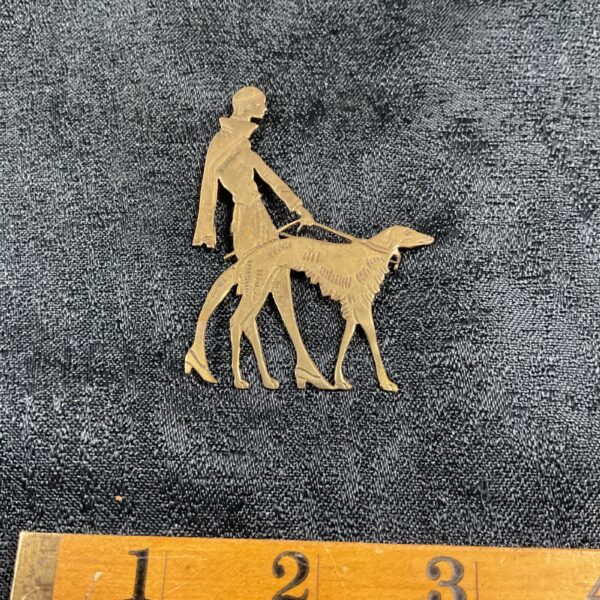 Vintage Art Deco brass brooch featuring a lady and Afghan Hound.