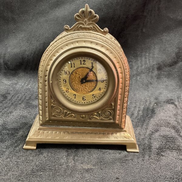 Vintage Art Deco mantle clock with brass detailing and black numerals.