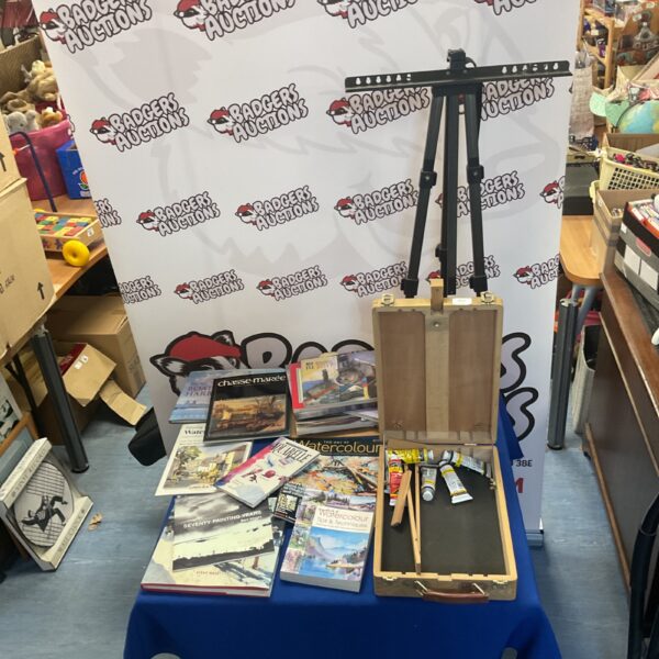 Art supplies lot featuring easel, magazines, and acrylic paints.