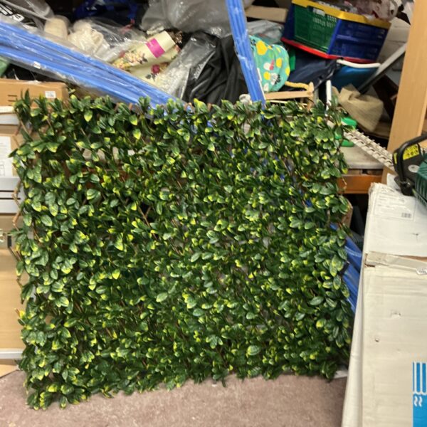 Close-up of the Hritow artificial hedge panel in a garden setting.