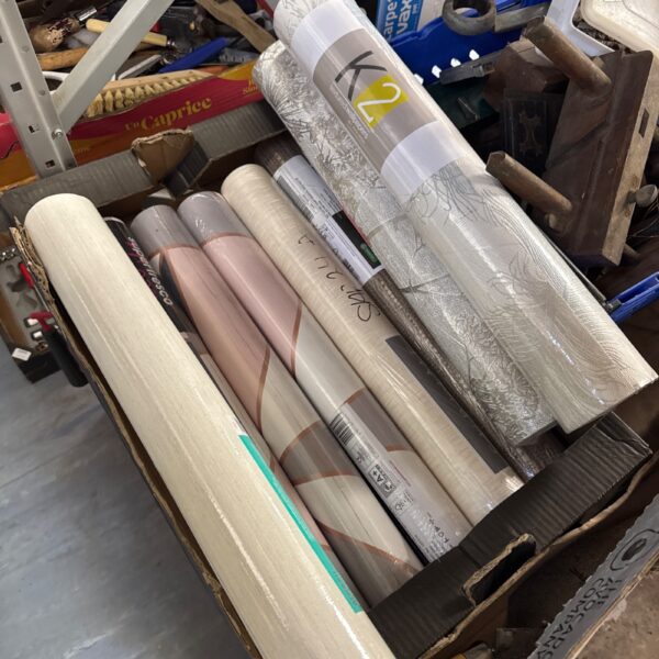 Assorted wallpaper rolls stacked, ideal for home decorating projects.
