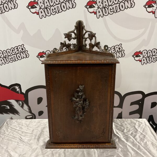 Antique Black Forest corner cabinet with carved details.
