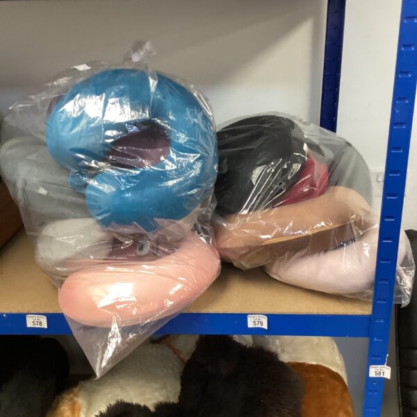 Sealed blue and pink neck pillows in plastic bags.