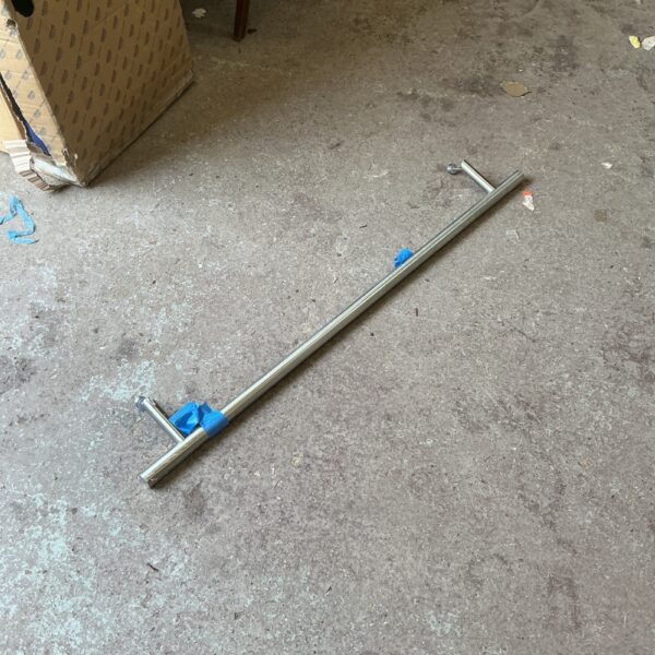 Brushed steel towel rail for bathroom heating and drying.