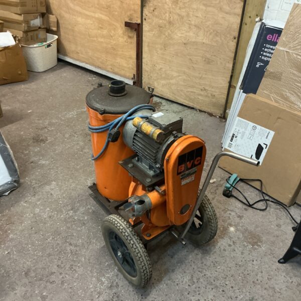 Vintage BVC industrial suction unit on wheels in a workshop setting.