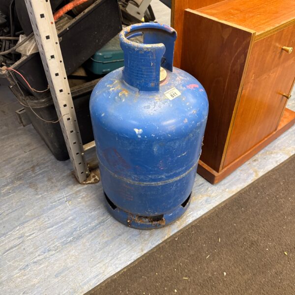 Blue Calor gas bottle with some contents, suitable for camping.