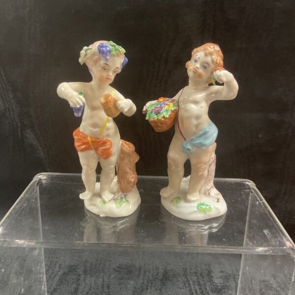 Vintage Capodimonte putti figurines, a charming pair on display.