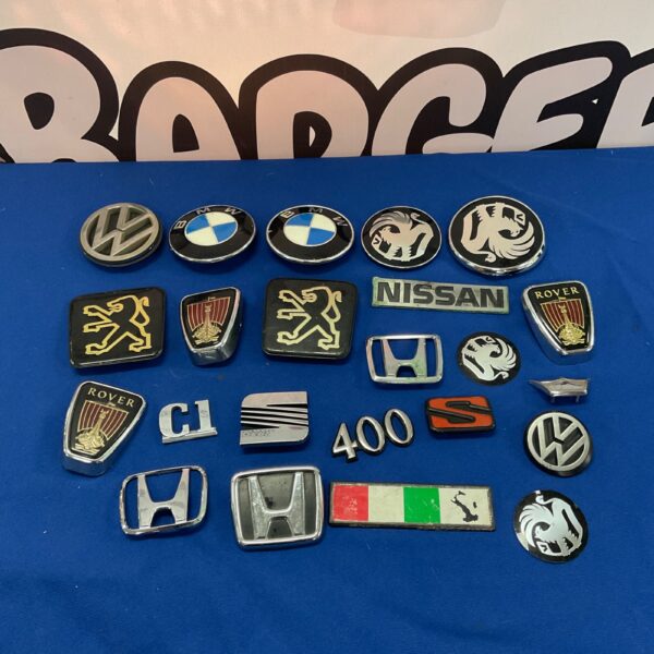 Collection of vintage car badges including Nissan, Vauxhall & Rover.