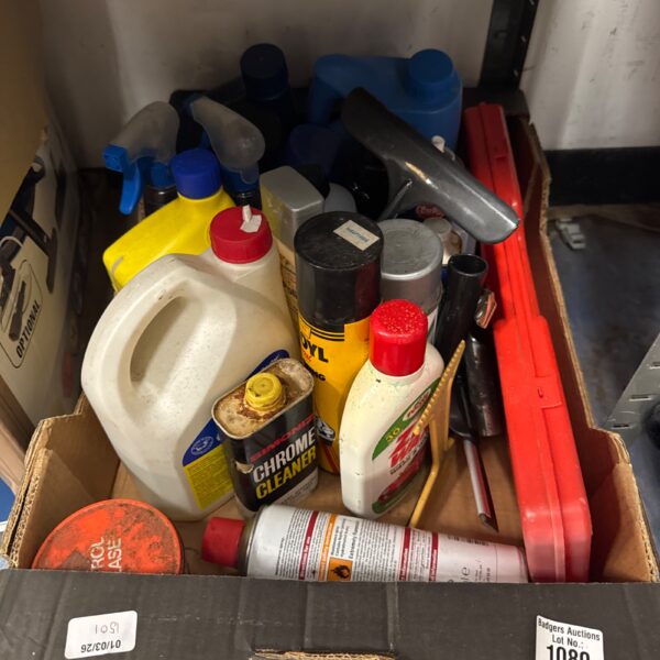 Selection of car polish and automotive fluids in a garage lot.