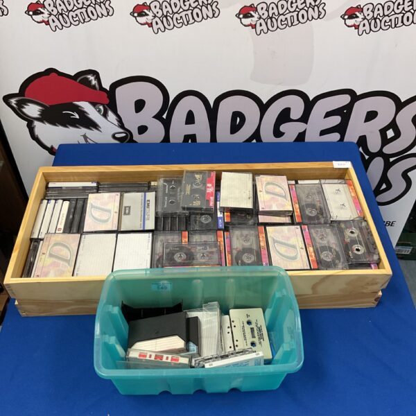 Large collection of vintage cassette tapes in a wooden crate.