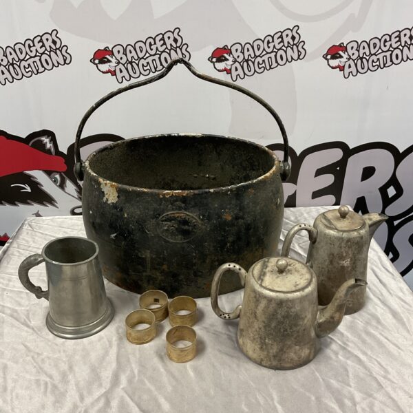 Antique cast iron cauldron with pewter tankard and silver teapots.
