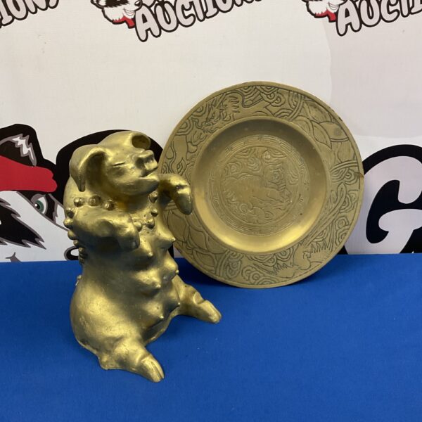 Antique Chinese brass pig figurine and dragon plate on blue background.