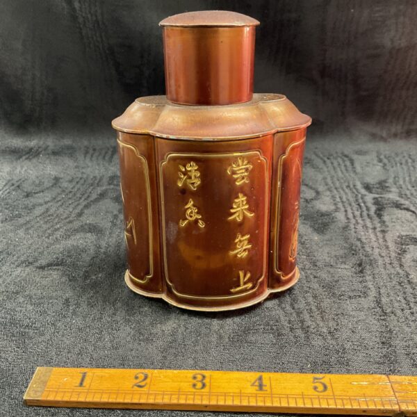 Antique Chinese tea caddy with embossed detailing and characters.