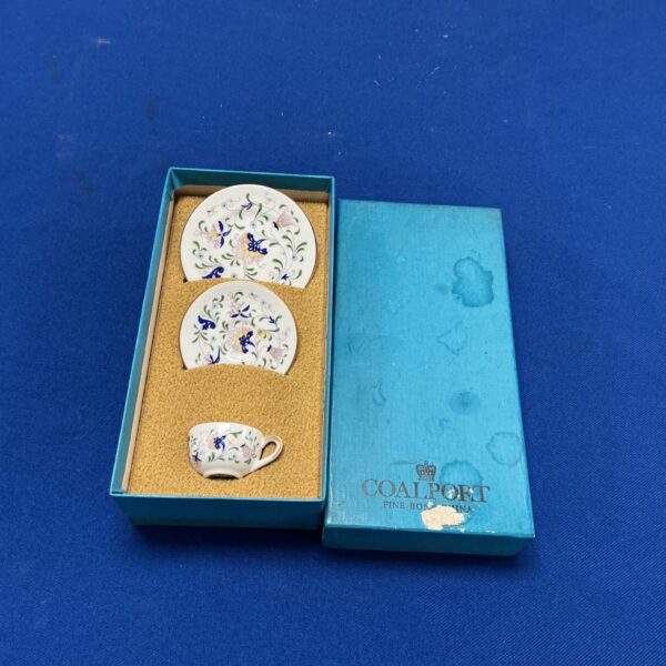 Delicate Coalport miniature cup and saucer with floral design.
