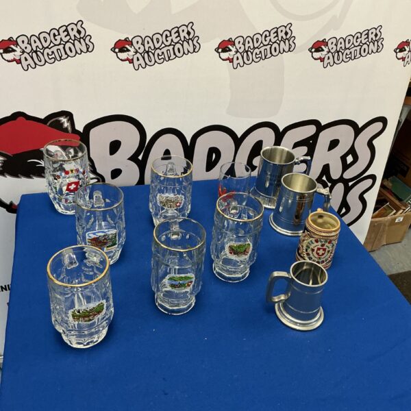 Lot of collectible beer tankards with decorative designs.
