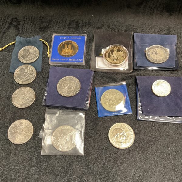 Collection of commemorative coins including £5 coins and a gold-plated crown.