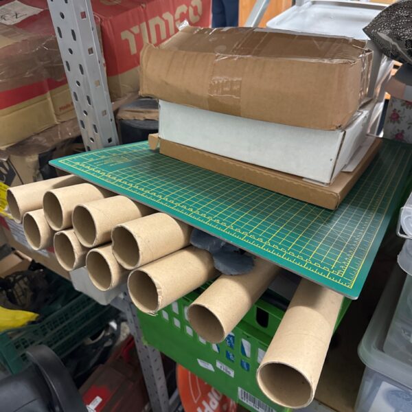 Overview of a large craft supply lot with cardboard tubes and cutting mat.