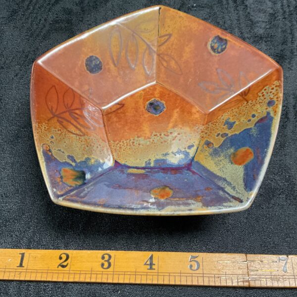 Handmade Dartington Pottery pentagonal bowl with vibrant glaze.