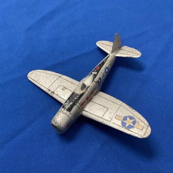 Vintage Dinky Toys P-47 Thunderbolt diecast plane on blue background.