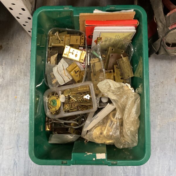 Assorted vintage door hinges and locks in a plastic storage box.