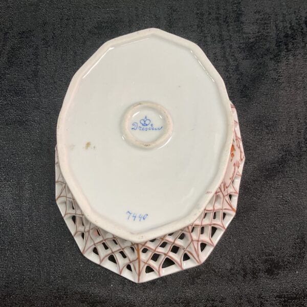 Antique Dresden porcelain basket with reticulated design and floral details.