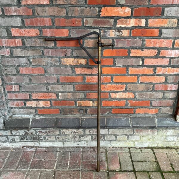 Antique Ernest H Hill Rosebury oil pump against brick wall.