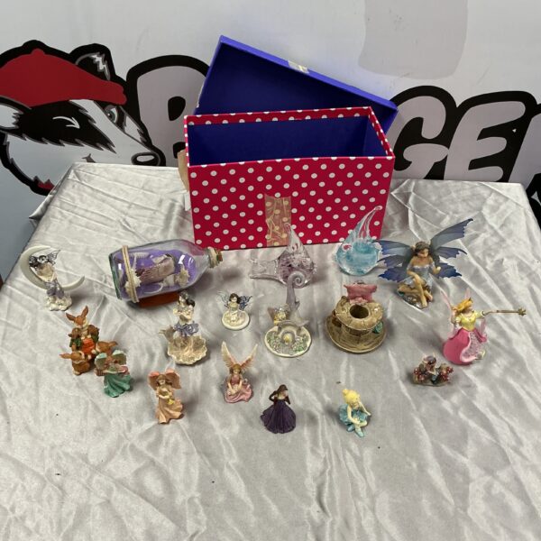 Close-up of fairy figures and glass fish display.