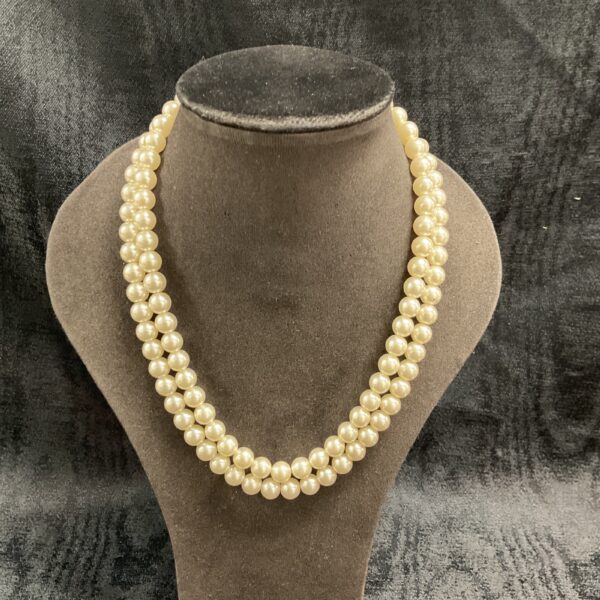 Elegant two strand faux pearl necklace on a display stand.