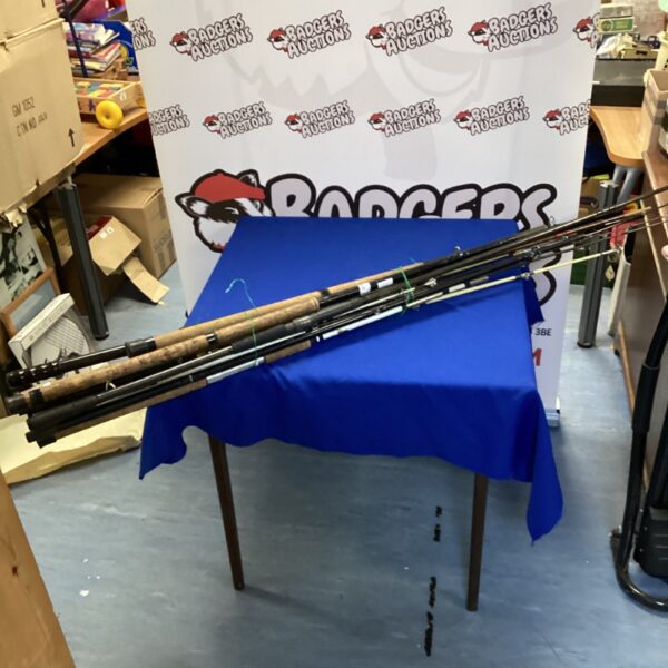 Bundle of vintage fishing rods on a blue table.