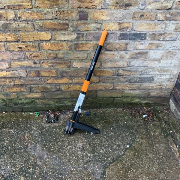 Long handled Fiskars weed puller for garden maintenance.