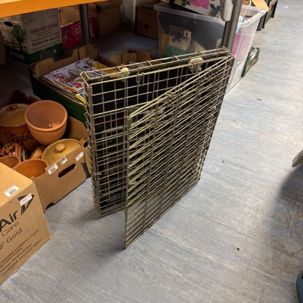Metal folding dog cage for small pets, showing signs of wear.