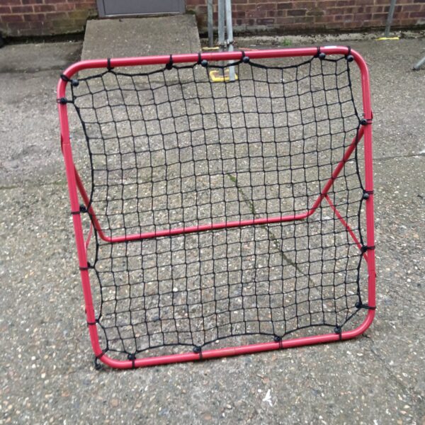Red football goal net for practice in the garden.