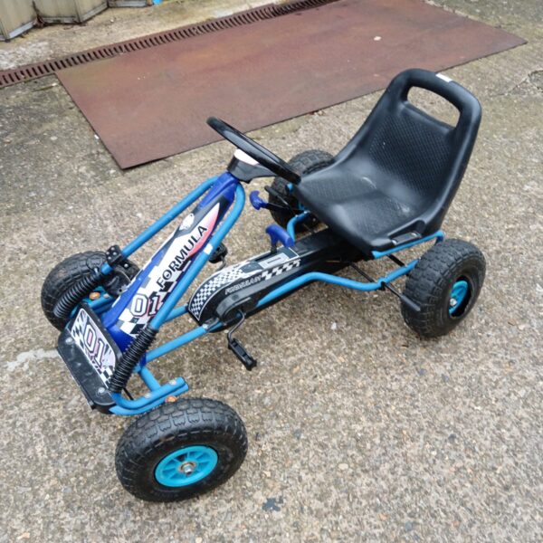 Bright blue Formula One pedal car for children's outdoor play.