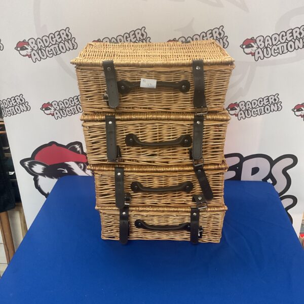 Stack of four small vintage wicker baskets with handles.
