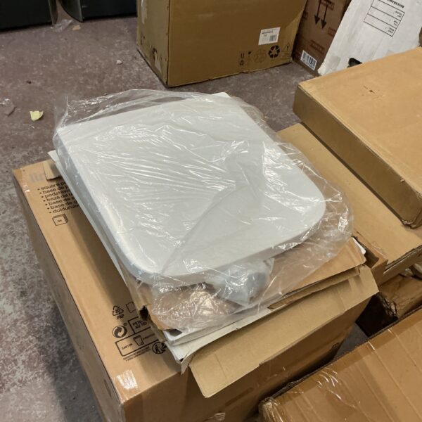 Sealed boxes of four new white toilet seats for bathroom use.