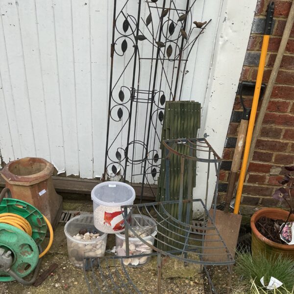 Decorative metal garden arch with scrolling design and leaf details.