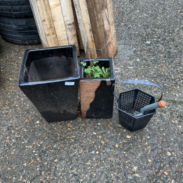 Dark garden pots with woven basket for outdoor plants.