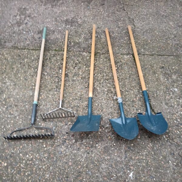 Vintage garden tool set featuring shovels and rakes for outdoor use.