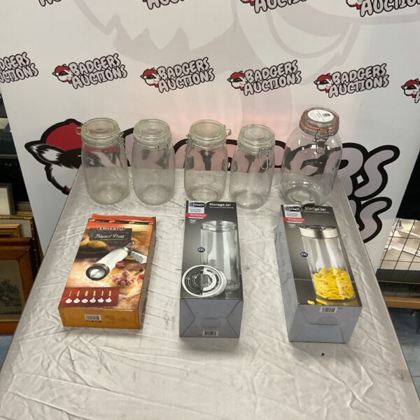 Vintage glass storage jars and biscuit press for kitchen storage and baking.
