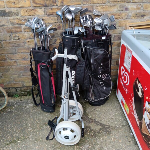 Large lot of vintage golf clubs with a trolley and bag.