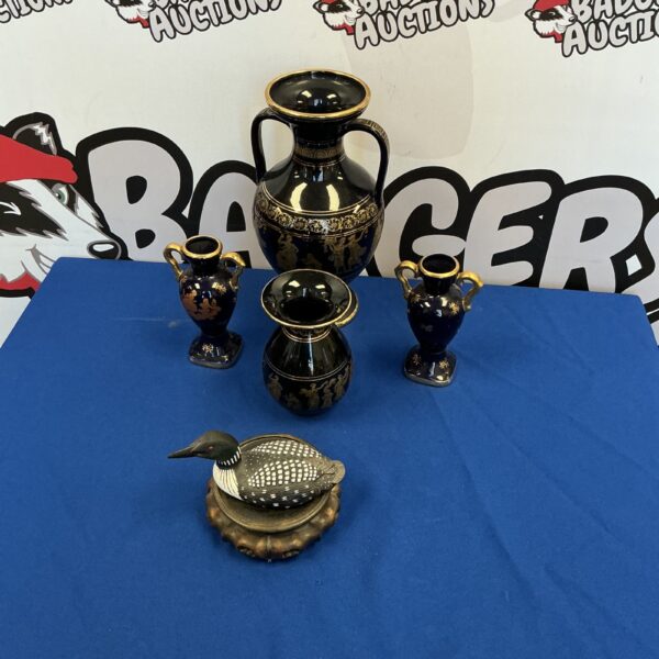 Vintage Greek pottery amphora with a black duck figurine.