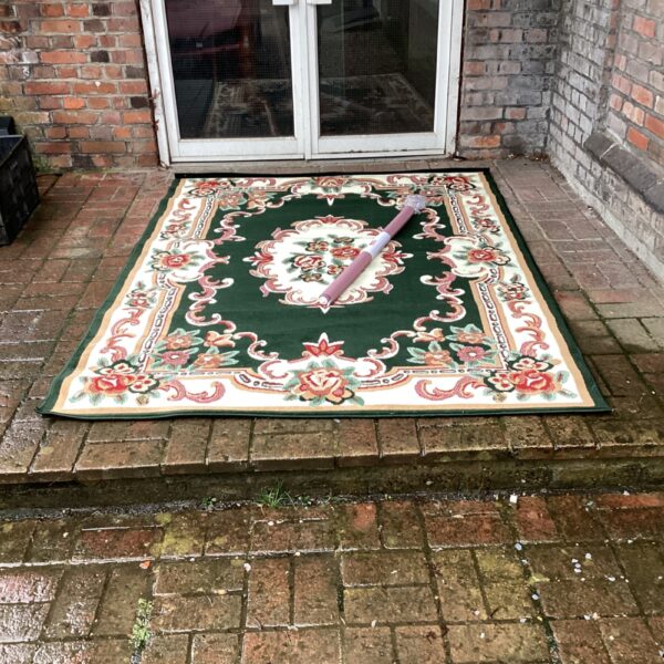 Large green floral rug with detailed pattern.