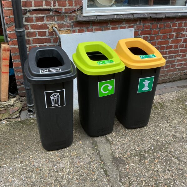 Three colourful recycling bins for garden waste separation.