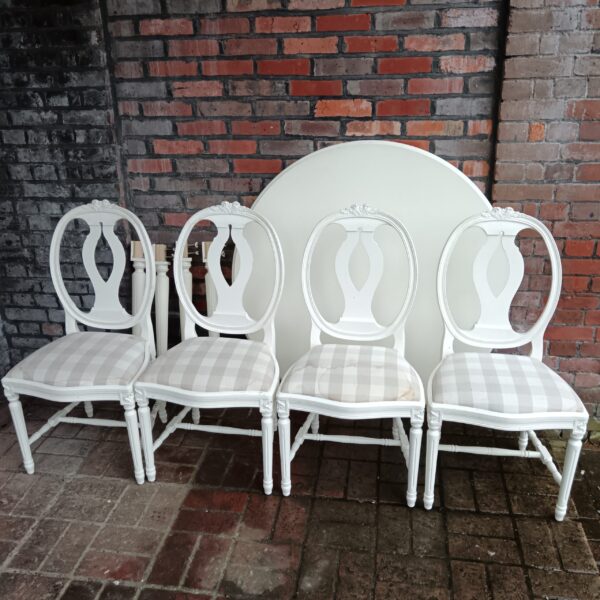 Antique Gustavian dining set with round table and painted chairs.