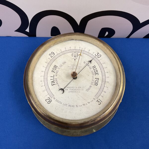 Vintage brass bulkhead barometer by H Hughes & Son for nautical use.