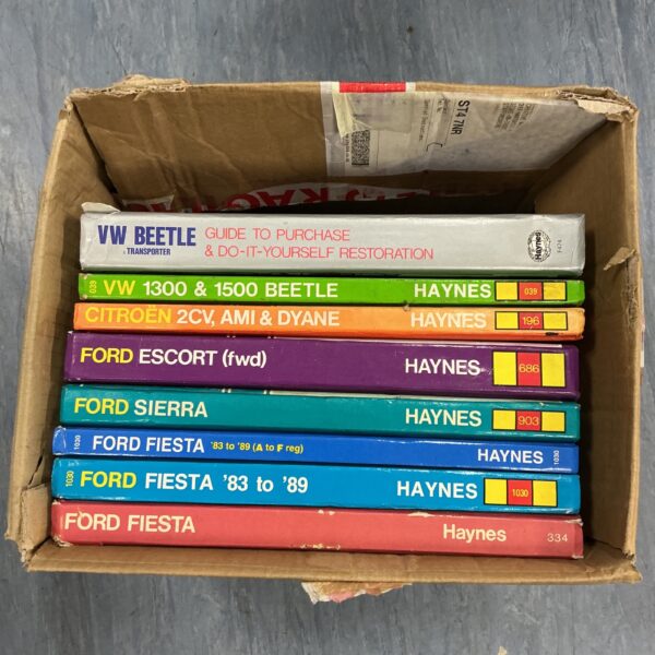 Lot of vintage Haynes car manuals for vehicle repair.