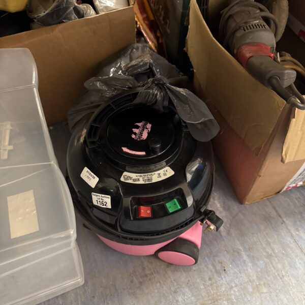 Red vintage Hetty Hoover cylinder vacuum cleaner with attachments.