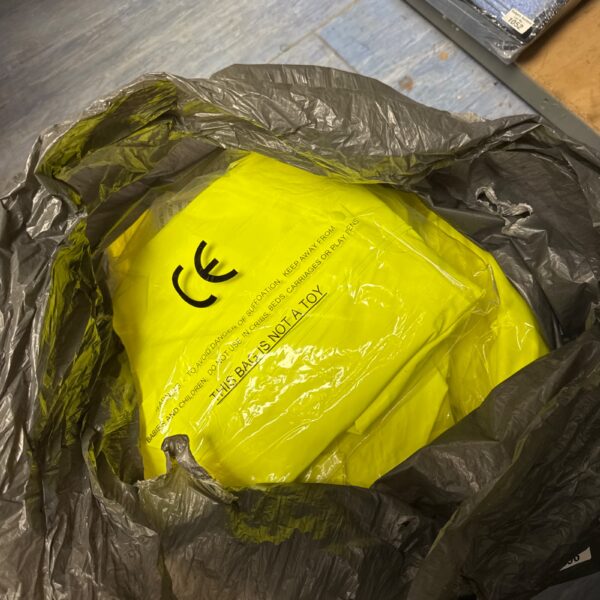 Large lot of new high visibility clothing in plastic packaging.