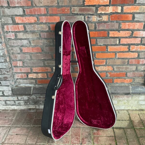 Red lined Hiscox acoustic guitar hard case for instrument protection.